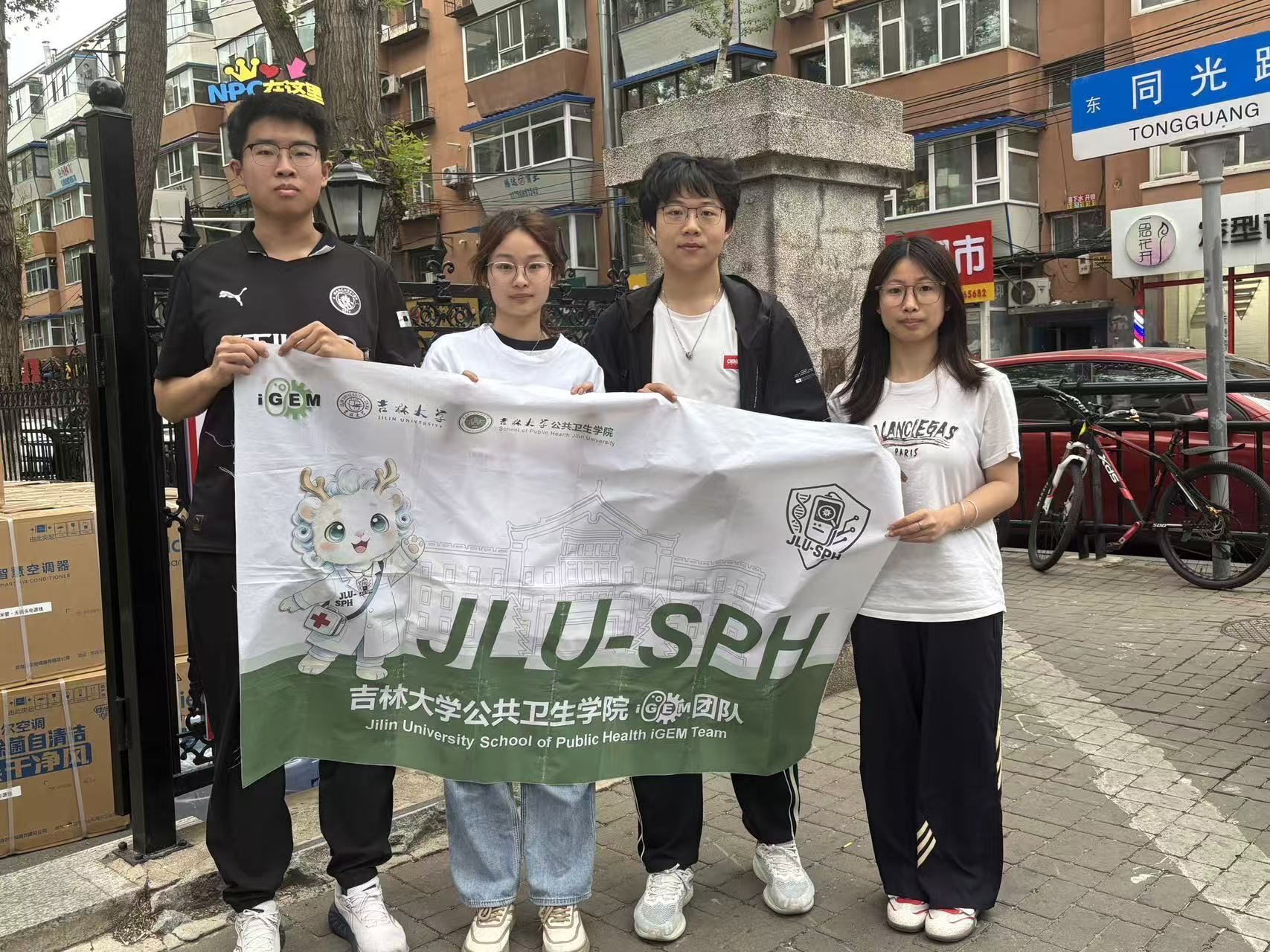 The outreach team holding their banner near the residence hall
