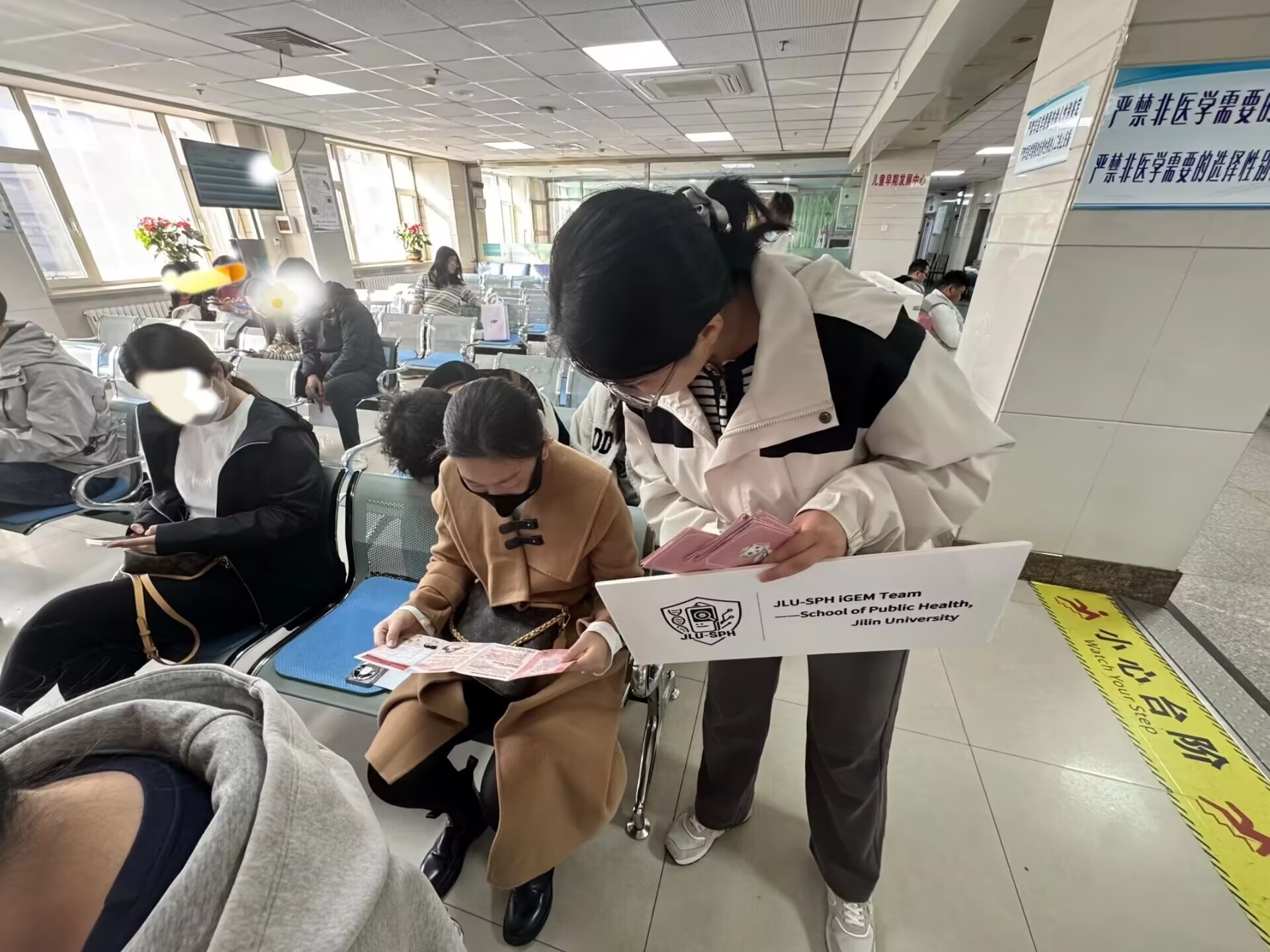 A team member discussing printed materials with a visitor in the waiting area