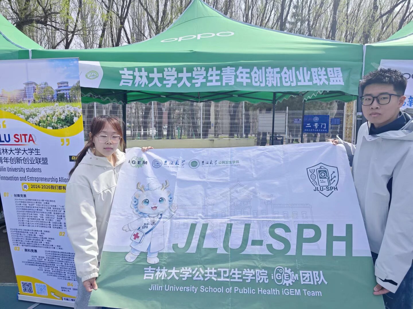 Team members holding the JLU-SPH banner at the fair