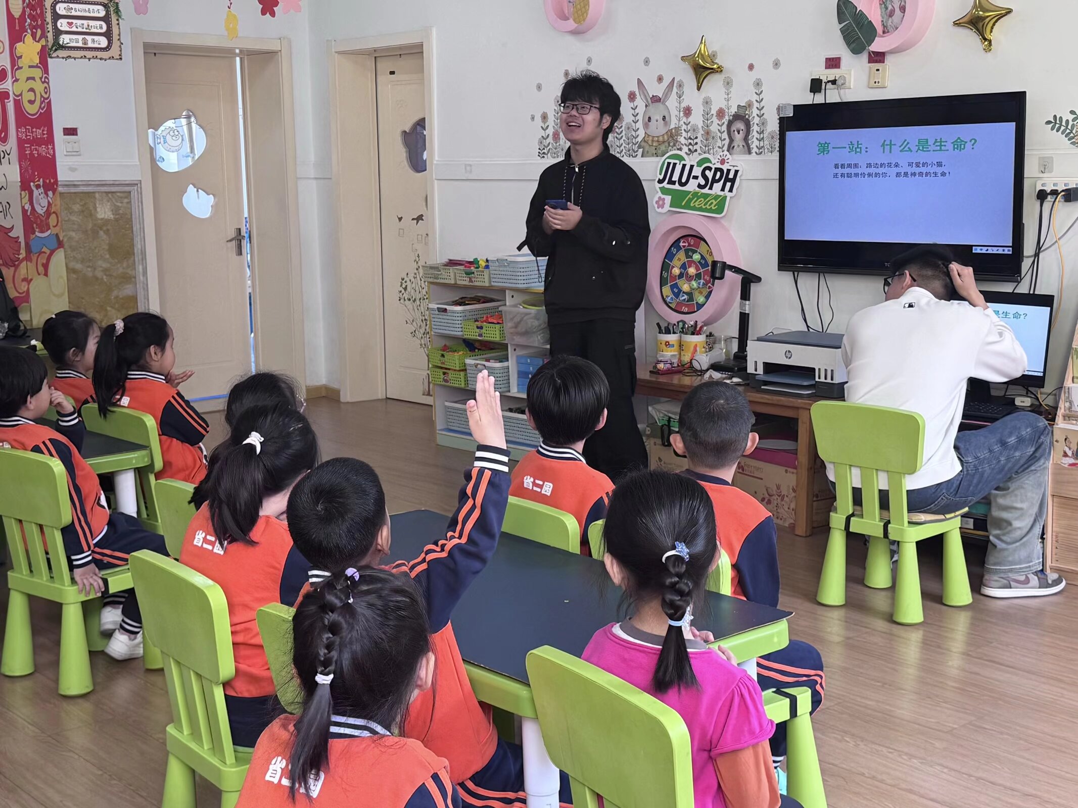 Children raising their hands during the Magic Bio-Bricks lesson