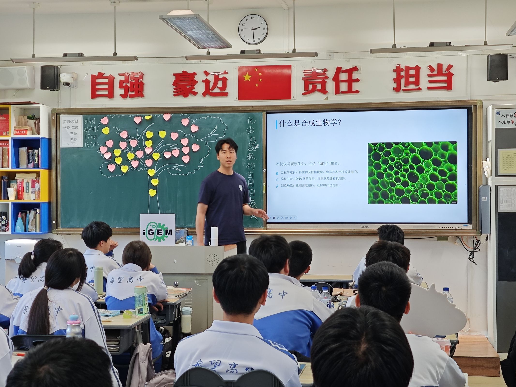 A presenter discussing synthetic biology with high-school students