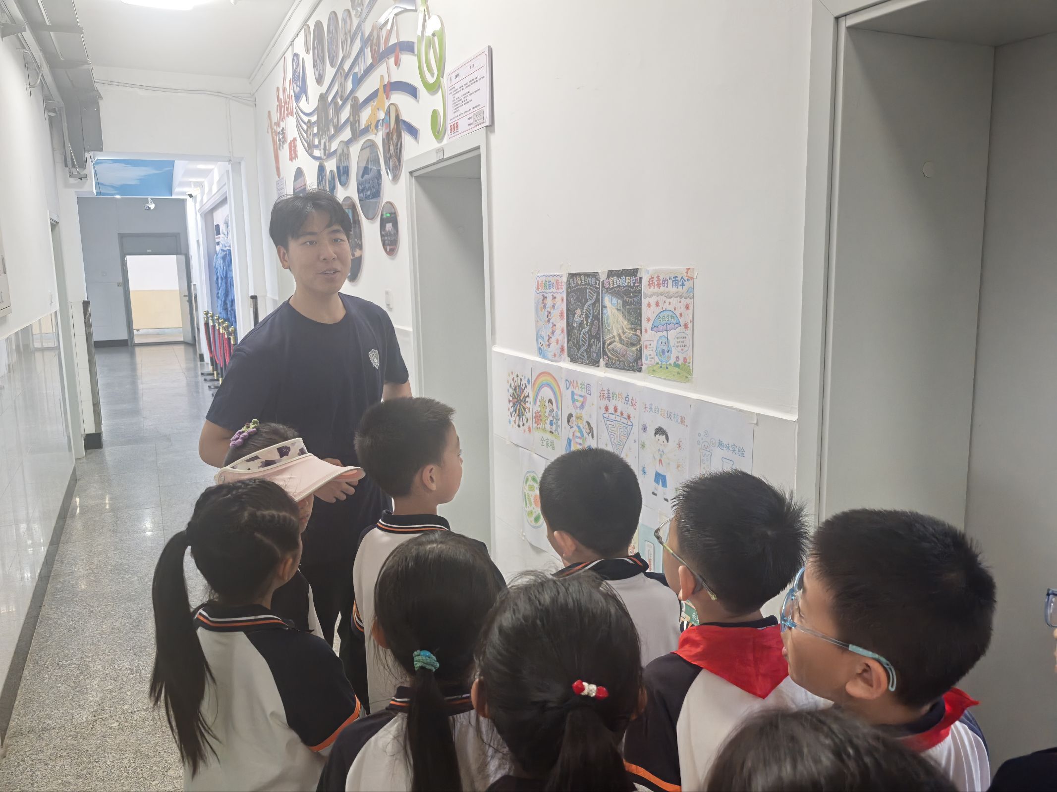 A volunteer talking with children beside the poster display