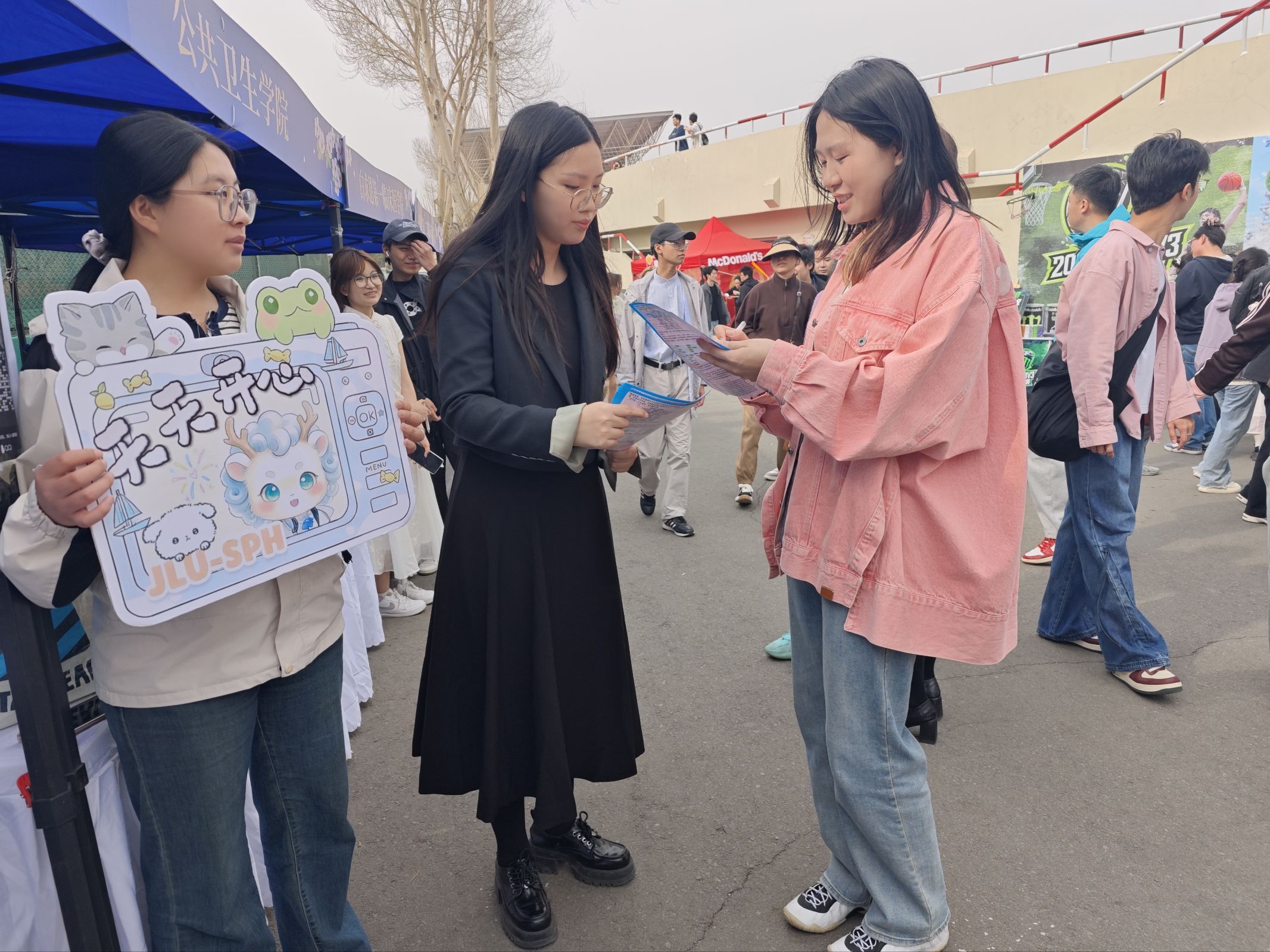 A volunteer discussing outreach materials with festival visitors