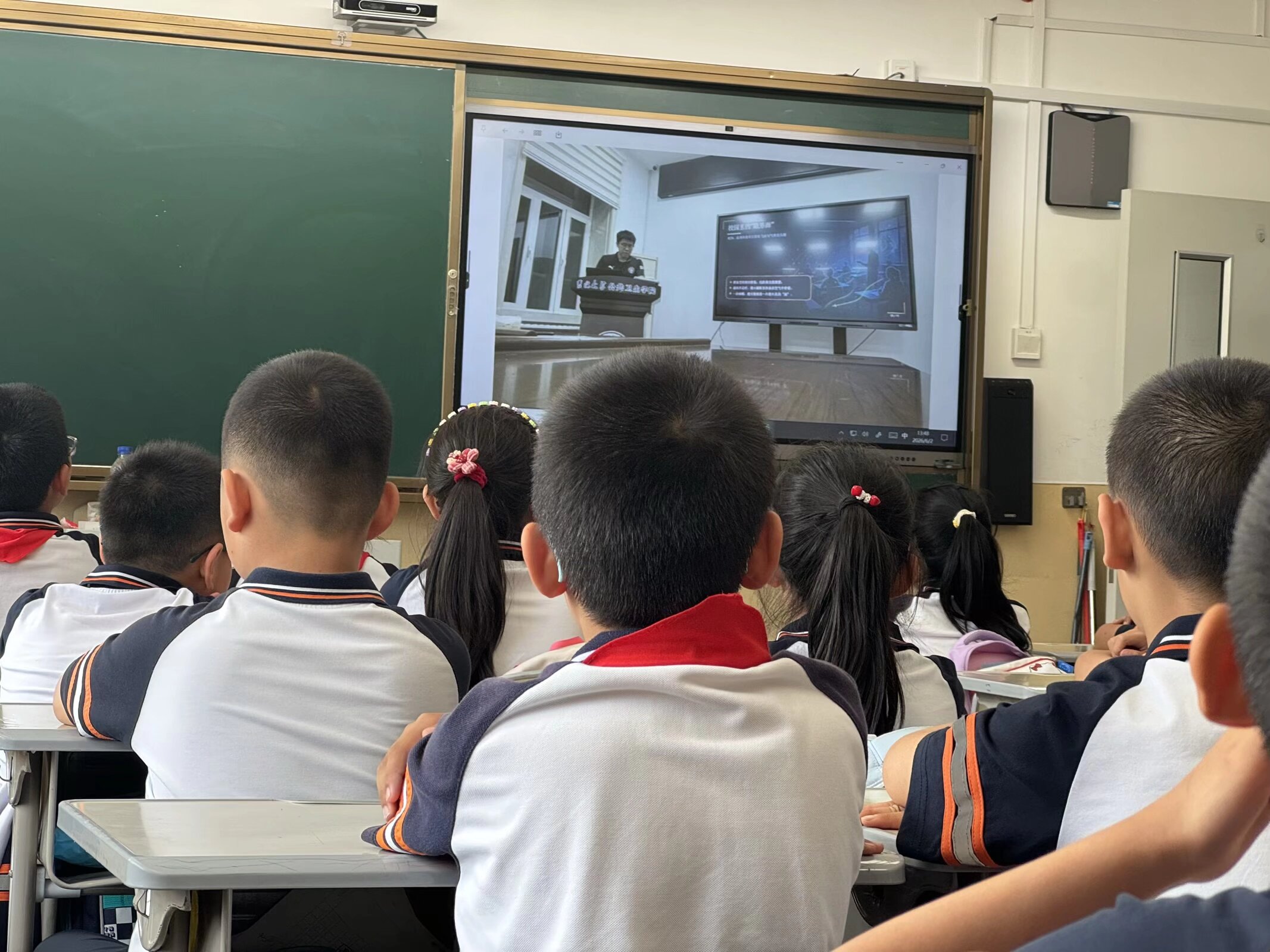 Children watching the online class on a classroom screen