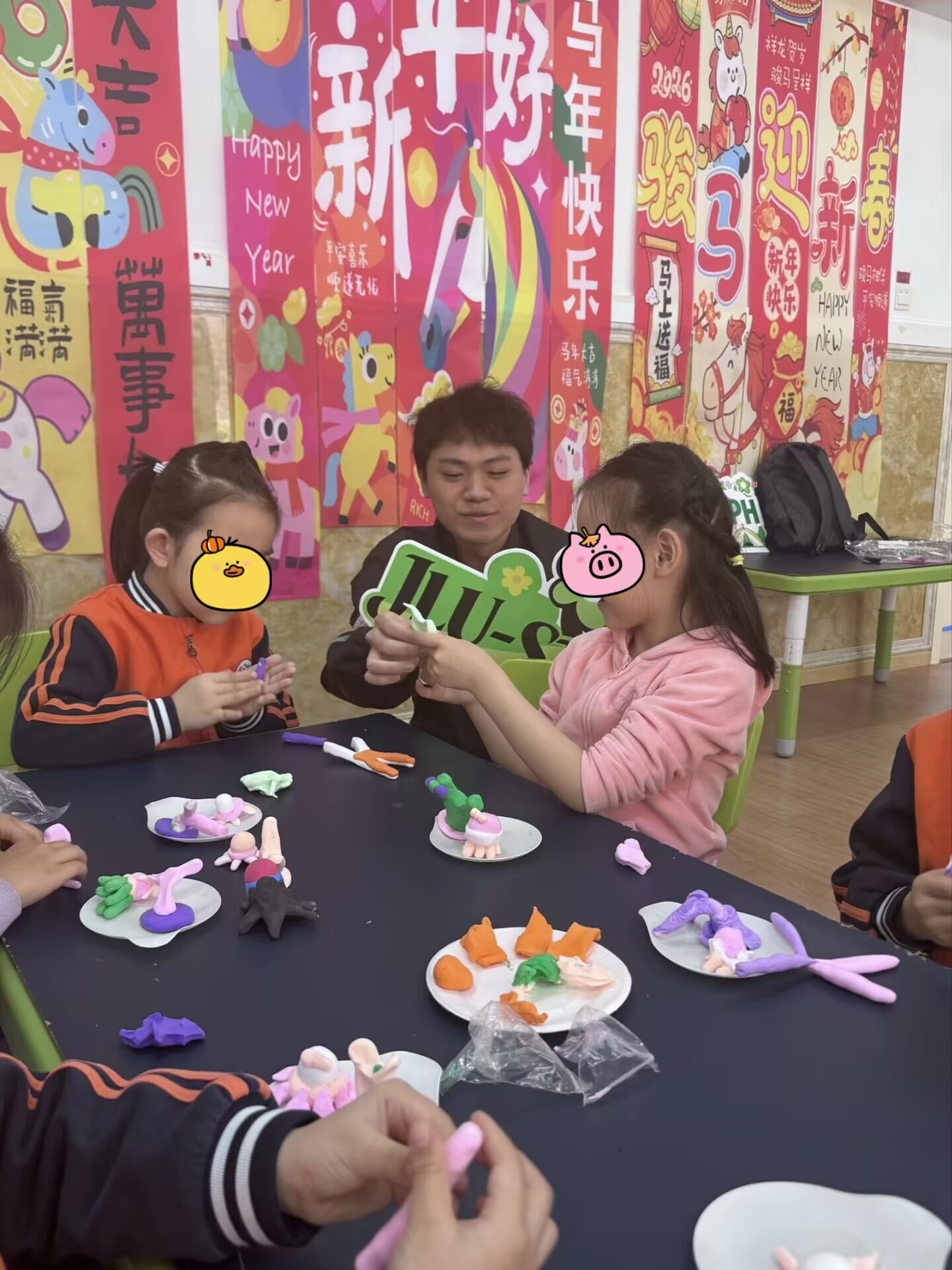 Children working on clay models with support from volunteers
