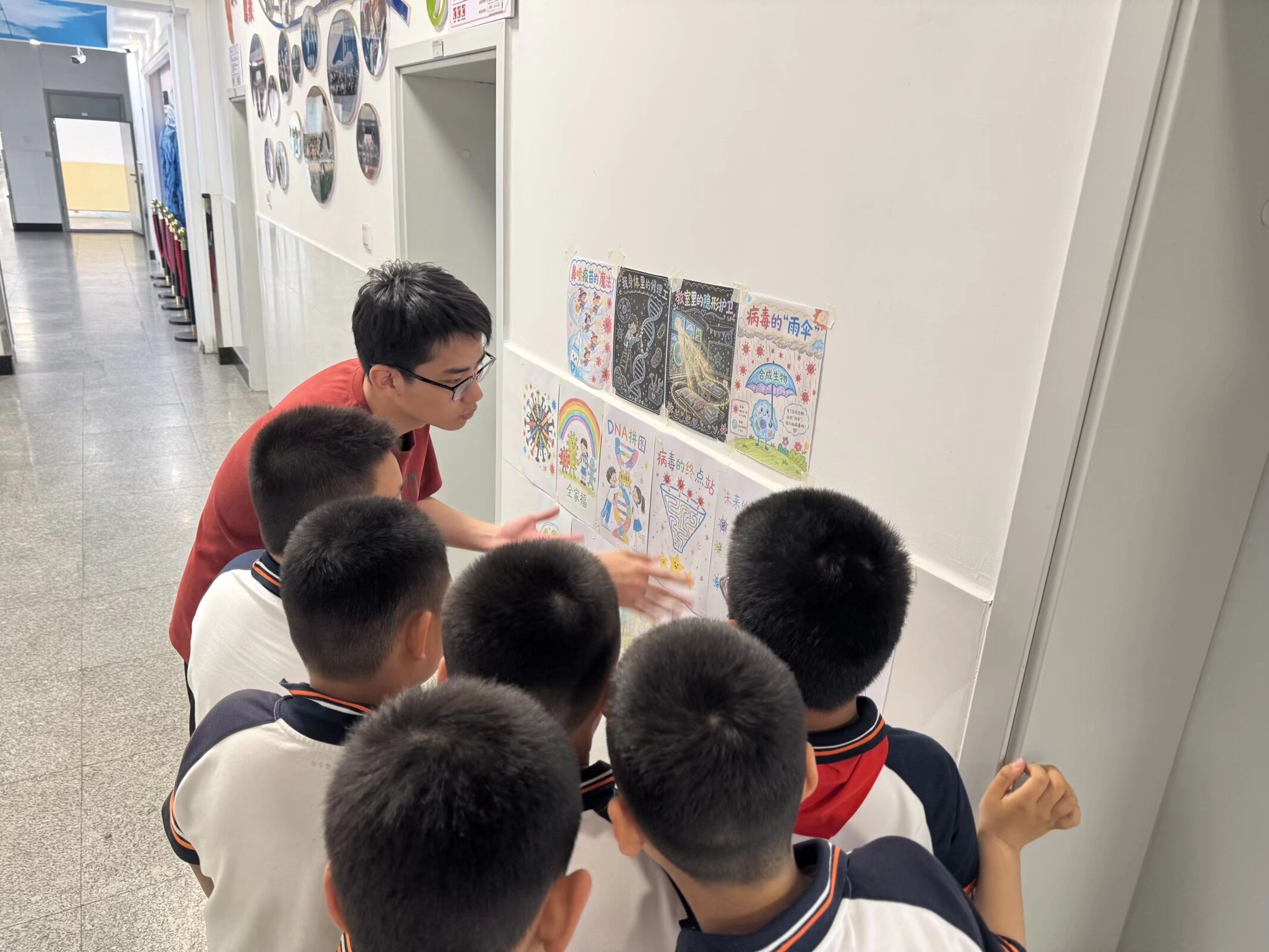 Children examining student-made science posters with a volunteer